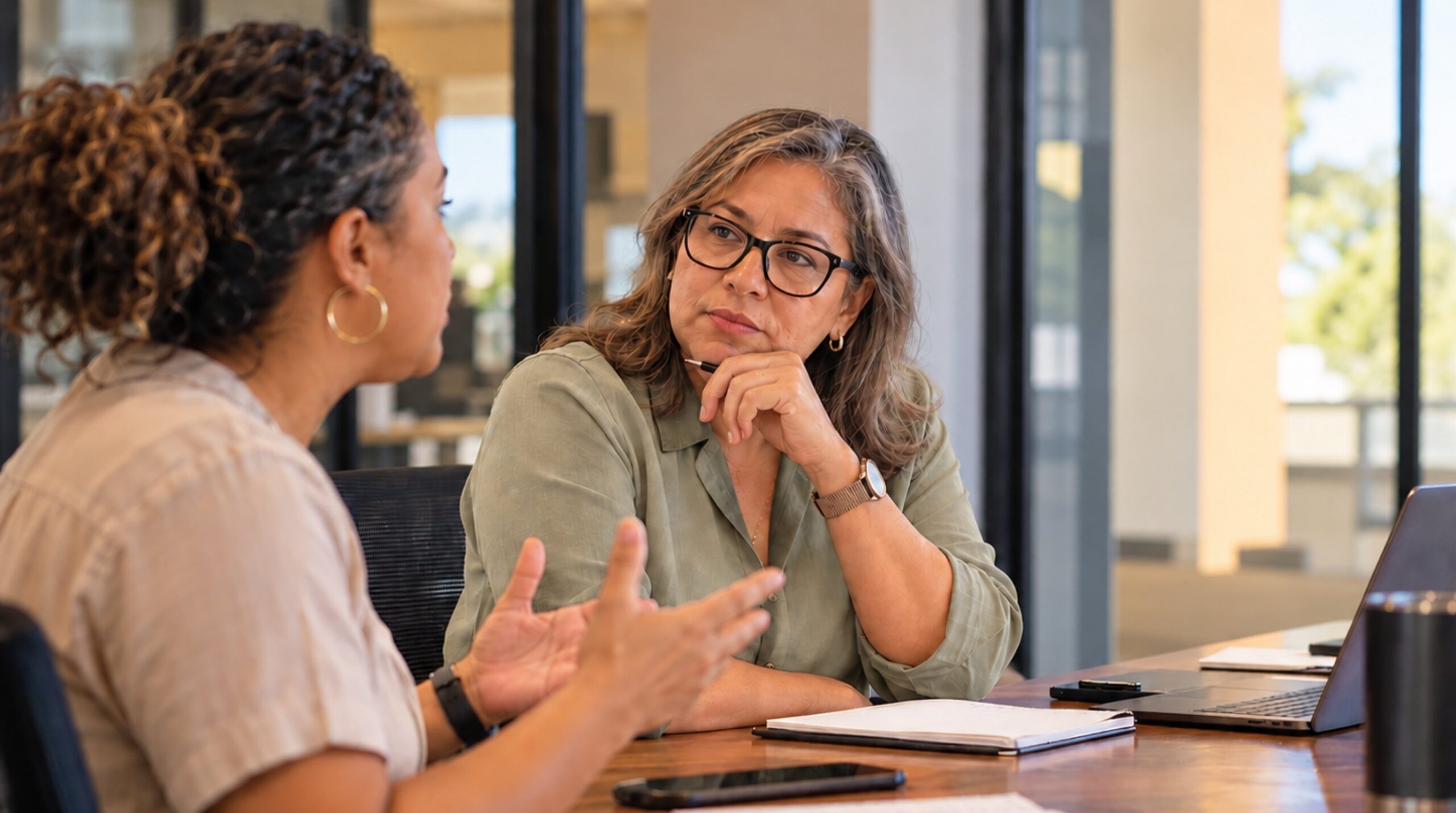 Manager listening thoughtfully to an employee during a workplace conversation, in the age of AI.